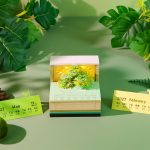 3D art calendar with realistic green tree design in paper cube shape, with LED light and loose leaf function. This desktop decoration is suitable for use as a note-taker and business gift.